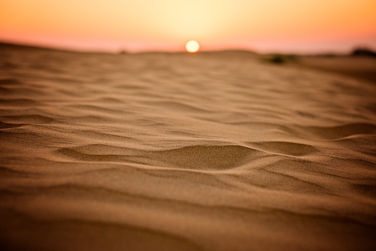 closeup shot of sand and Sunset on Camel Safari