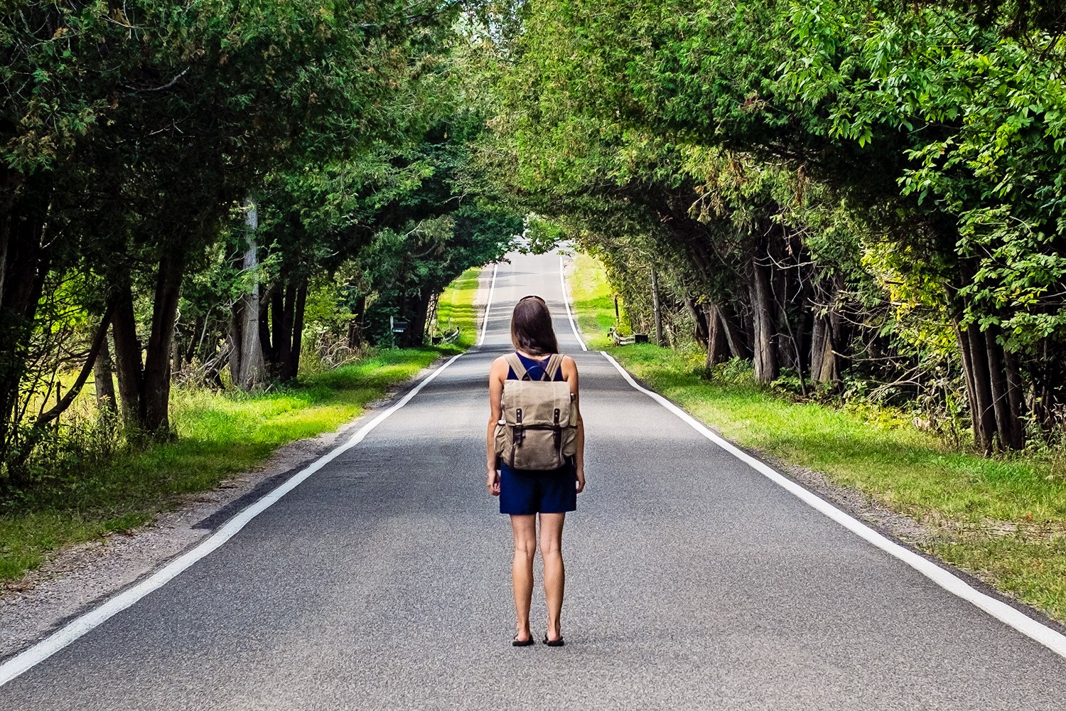 a woman standing on an empty road